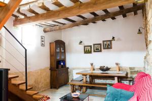 a living room with a wooden table and a wooden stairway at Casa Rural La Pinocha in Sigüenza