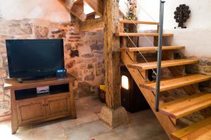 a living room with a tv on a wooden shelf at Casa Rural La Pinocha in Sigüenza