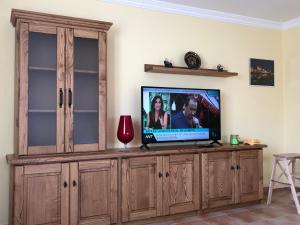 einen Fernseher auf einem hölzernen Entertainment-Center in einem Wohnzimmer in der Unterkunft Villa La Encina in Quijas + 12 Fotos