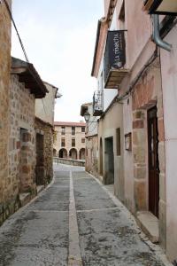 an empty street in an old town with buildings at Casa Rural La Pinocha in Sigüenza