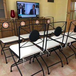 eine Gruppe von Stühlen vor einem TV in der Unterkunft Villa La Encina in Quijas