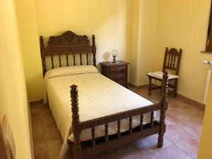 1 dormitorio con 1 cama de madera y 2 mesitas de noche en Villa La Encina, en Quijas