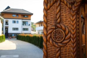 a wooden door with a symbol on the side of a building at Pensiunea Maramures Guesthouse in Vişeu de Jos