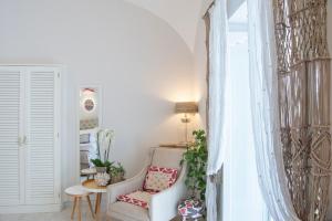 uma sala de estar com uma cadeira e uma mesa em Casa Buonocore em Positano