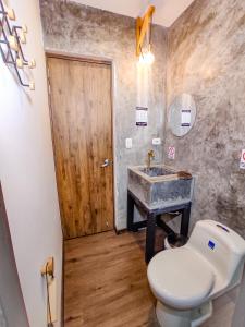 uma casa de banho com um WC e um lavatório em Ecohotel Monte Tierra Habitaciones y Glamping em Filandia