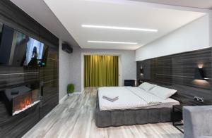 a bedroom with a bed and a tv and a fireplace at Luxrent Kreshatik Arenacity SkyBar in Kyiv