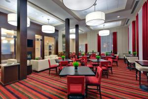 um restaurante com cadeiras e mesas vermelhas e mesa de cabeceira em Holiday Inn Express Hotel & Suites Chatham South, an IHG Hotel em Chatham