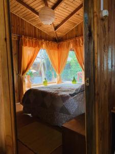 1 dormitorio con cama y ventana en Cabaña Las Patagüas - Coñaripe en Coñaripe