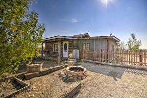 une petite maison en bois avec une clôture et une cour dans l'établissement Hundred-Year-Old Shell Valley Settlers Cabin!, à Shell