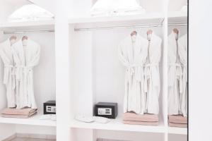 a dressing room with white clothes on hangers at Stelia Mare Boutique Hotel in Naousa