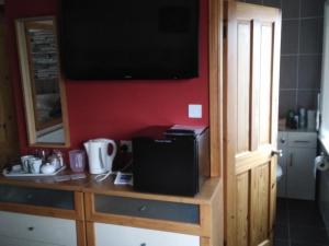 a kitchen with a counter with a television on a wall at 24 Fairfield Road in Uttoxeter