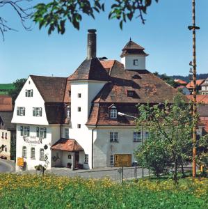 um grande edifício branco com telhado em Gasthof Russenbräu em Tiefenbach