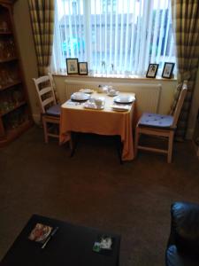 uma mesa e cadeiras num quarto com uma janela em 24 Fairfield Road em Uttoxeter