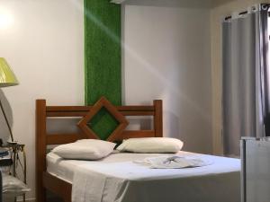 een slaapkamer met een bed met een groene muur bij Hotel Olivier in Três Rios