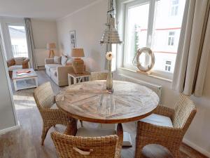 - une salle à manger avec une table et des chaises en bois dans l'établissement Residenz "bel-vital" Binz - WG28 mit kleinem Meerblick und Balkon, à Binz