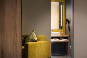 a living room with a yellow chair and a mirror at Holiday Inn - Hamburg - HafenCity, an IHG Hotel in Hamburg