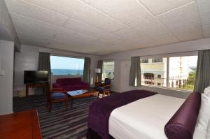 a hotel room with a bed and a living room at Sea Club Ocean Resort in Fort Lauderdale