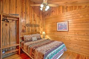 um quarto com paredes de madeira e uma cama num quarto em Timber Brooke Cabin Hot Tub and Central Location! em Broken Bow