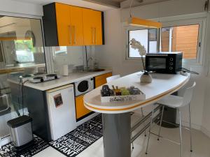 a small kitchen with a table and a microwave at Bungalow et jacuzzi privatifs in La Possession