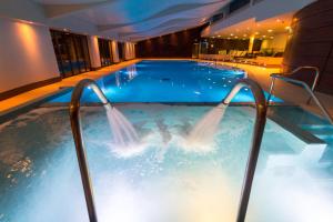 a swimming pool filled with water and a large glass table at The Mere Golf Resort & Spa in Knutsford