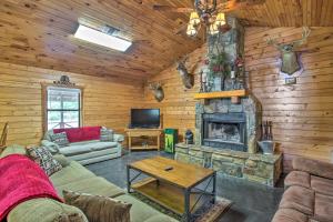 a living room with a stone fireplace in a cabin at Peaceful Pet-Friendly Retreat with Private Hot Tub! in Broken Bow