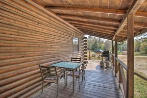 a wooden deck with a table and chairs on it at Peaceful Pet-Friendly Retreat with Private Hot Tub! in Broken Bow