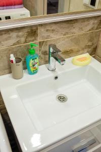 a bathroom sink with a bottle of soap and a detergent at ApartLux on Slavskogo 14 in Ustʼ-Kamenogorsk