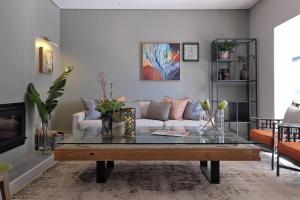 a living room with a couch and a coffee table at The Tree House Boutique Hotel by The Living Journey Collection in Cape Town +67 photos