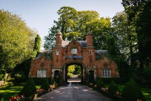 an entrance to a red brick house with a sign that reads the were at Fairmont Cheshire The Mere in Knutsford