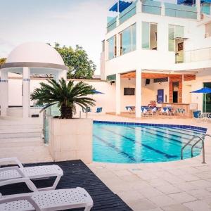 een zwembad met twee witte stoelen en een gebouw bij Hotel Boutique San Rafael in Mariquita