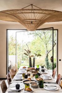 una mesa larga con comida en una habitación con ventana en Gîte Au Bout du Verger, en Les Molières