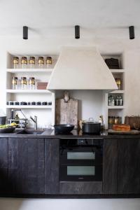 a kitchen with a sink and a stove top oven at Gîte Au Bout du Verger in Les Molières