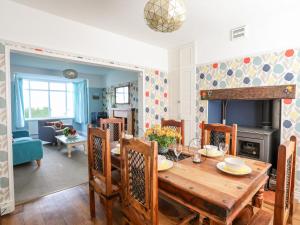 comedor y sala de estar con mesa de madera en Bryngwyn - Trearddur Bay, en Holyhead