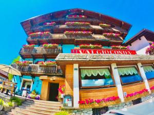 a building with lots of flower boxes on it at Hotel Valgioconda in Sappada