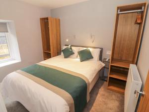 a bedroom with a large bed with green pillows at Annest in Bangor