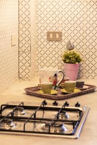 Una estufa con dos tazas y una bandeja sobre una encimera. en Casa Pitea, en Mondello