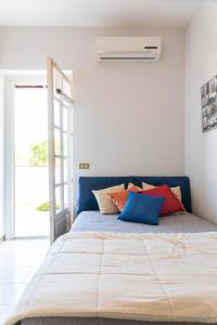 Un dormitorio con una cama grande con almohadas de colores. en Casa Pitea, en Mondello