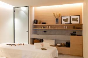 a bathroom with a white bed and a mirror at Auberge Du Père Bise - Jean Sulpice in Talloires