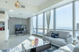 a living room with a couch and a tv at Pristinely furnished 3BR and maids Amazing Sea Views in Dubai