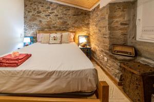 een slaapkamer met een bed in een stenen muur bij O Palheiro - Vista Panorâmica e Jacuzzi in Sobreira Formosa