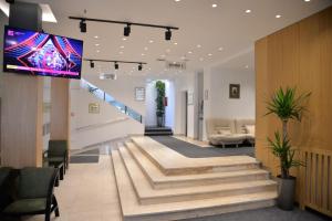 a lobby with stairs and a flat screen tv at Hotel Požega in Požega