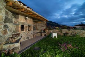 a stone building with a table in a yard at O Palheiro - Vista Panorâmica, Jacuzzi e Piscina in Sobreira Formosa