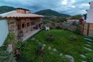 a backyard of a stone house with a garden at O Palheiro - Vista Panorâmica e Jacuzzi in Sobreira Formosa