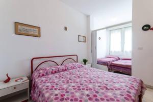 1 dormitorio con 1 cama con edredón rosa en Cortina 1-85, en Lido di Pomposa