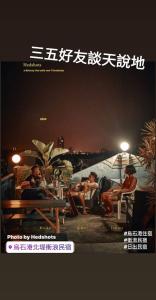 a poster of people sitting on a beach at night at Wushih Surf Hostel in Toucheng