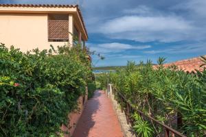 a walkway leading up to a house with trees at Baia de Bahas Residence in Golfo Aranci