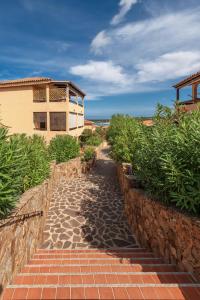 a brick path leading to a building on the beach at Baia de Bahas Residence in Golfo Aranci