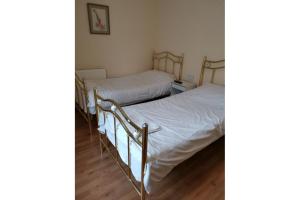 two beds in a room with white sheets at Oyo Swan Inn, Heathrow Airport in Stanwell