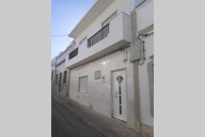 un edificio blanco con una puerta en una calle en A Casa da Avo Dina, en Fuseta