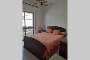una camera da letto con un letto con cuscini rosa e una finestra di A Casa da Avo Dina a Fuzeta
